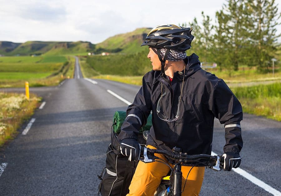 Biker on the road with mountains in Iceland in the background