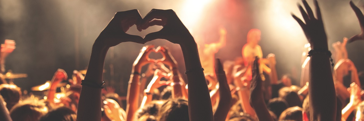 Person at concert with arms in air