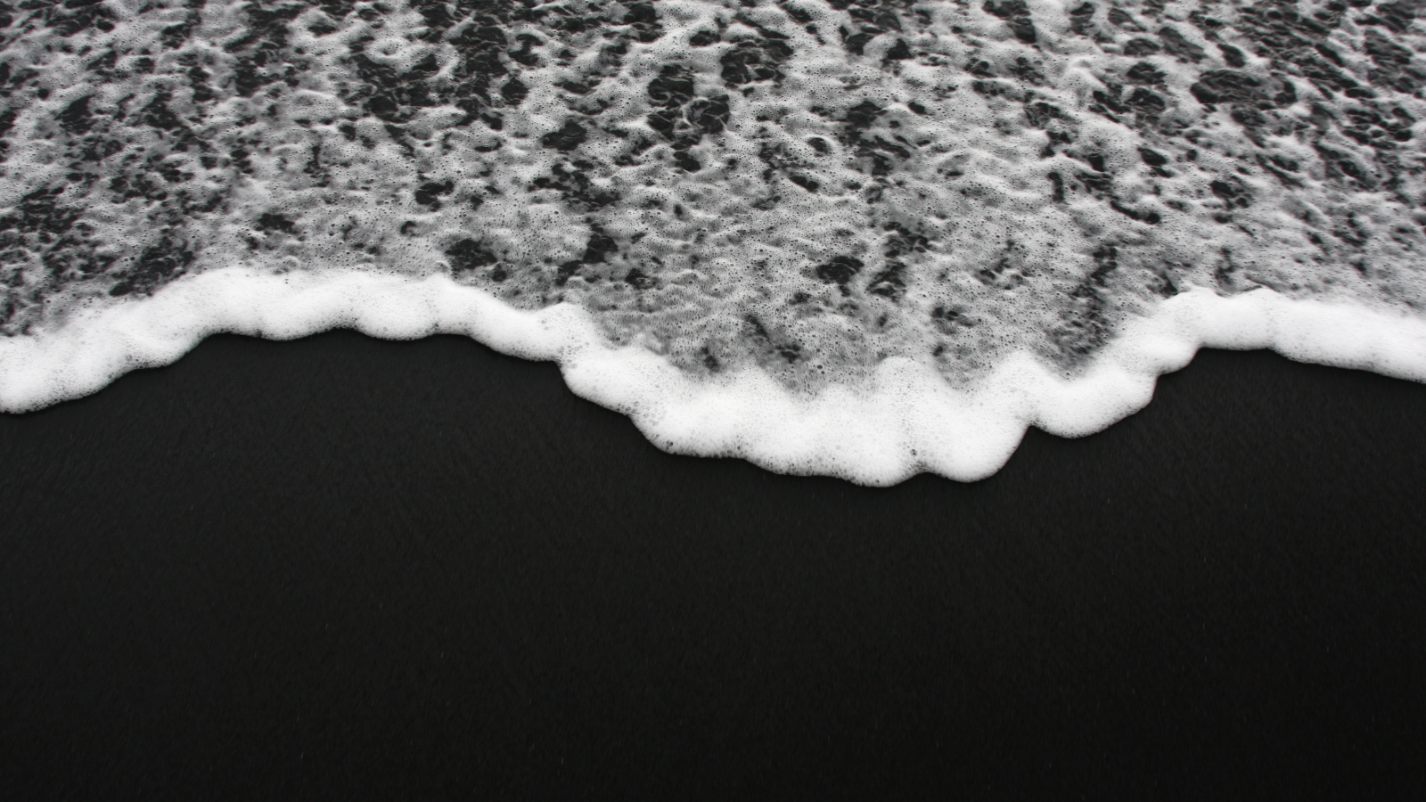 Wave crashing on black sand on a beach in Iceland.Wave crashing on black sand on a beach in Iceland.