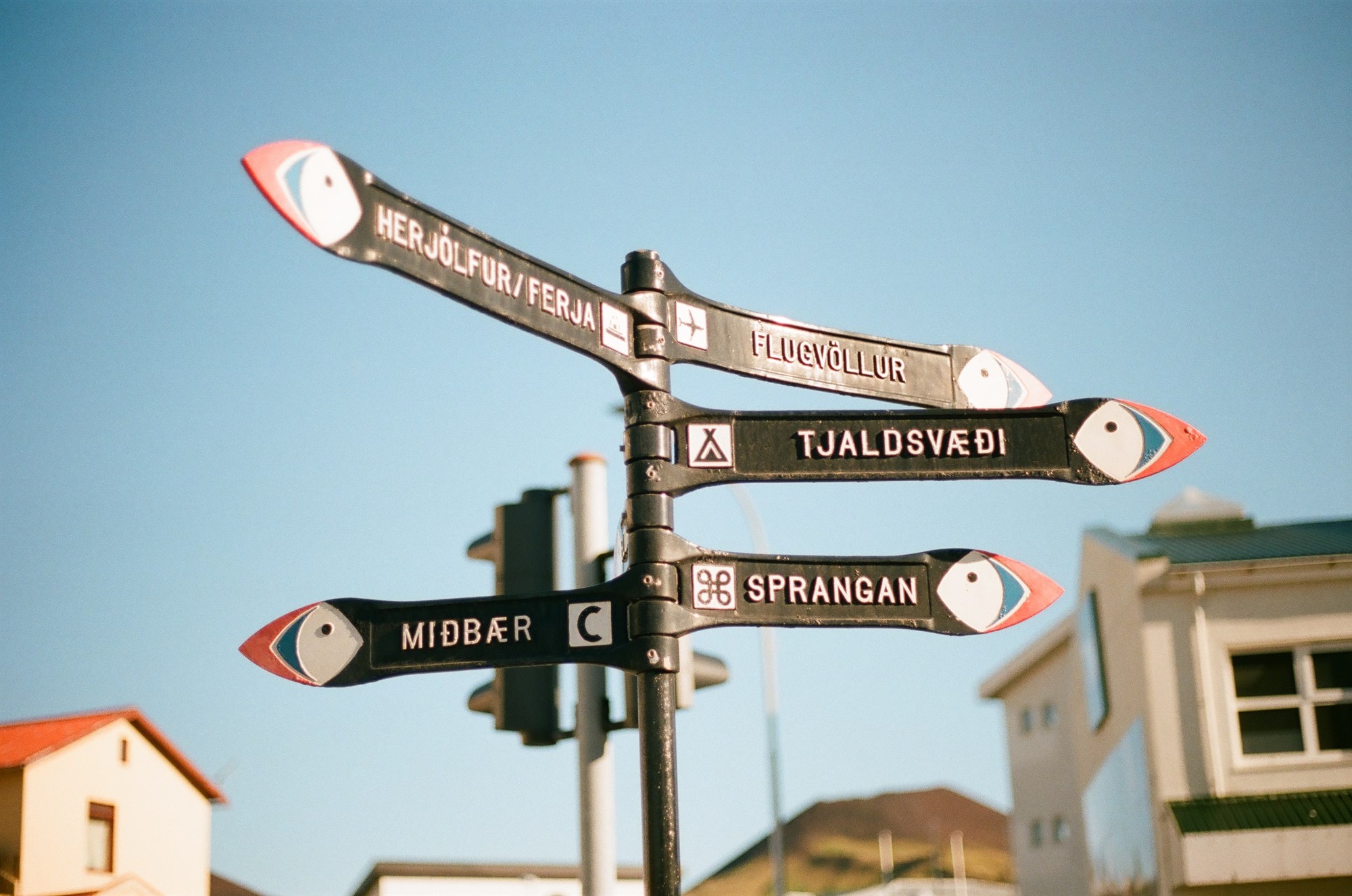 Black sign with different direction arrows and Icelandic place names.