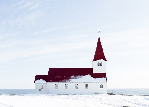  White Church with a red roof surrounded by snow, Iceland.