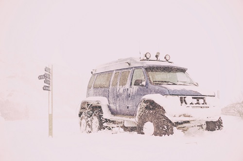 4X4 blue truck surrounded by thick snow, Iceland  