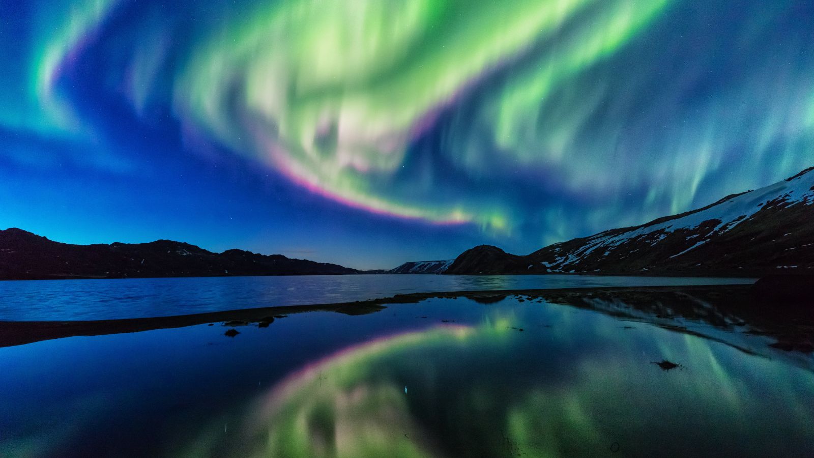 Northern Lights over a body of water, Iceland.