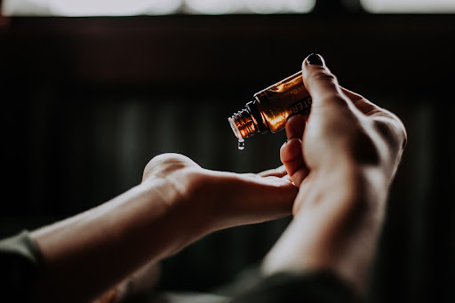 Massage oil dripping from a bottle onto a hand