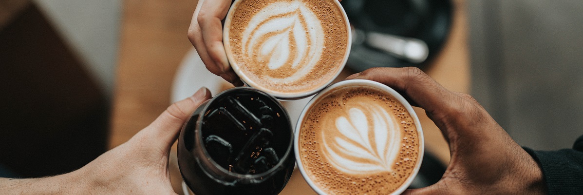People holding coffee cups in a coffee shop