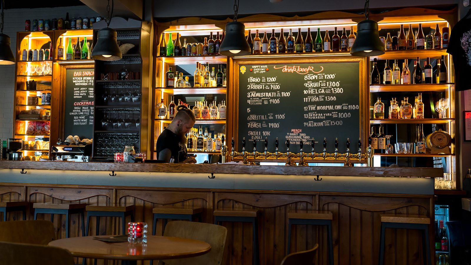 Barman working behind the bar at an Icelandic pub. 