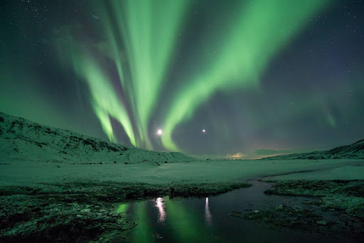 Northern lights over snowy plain Iceland