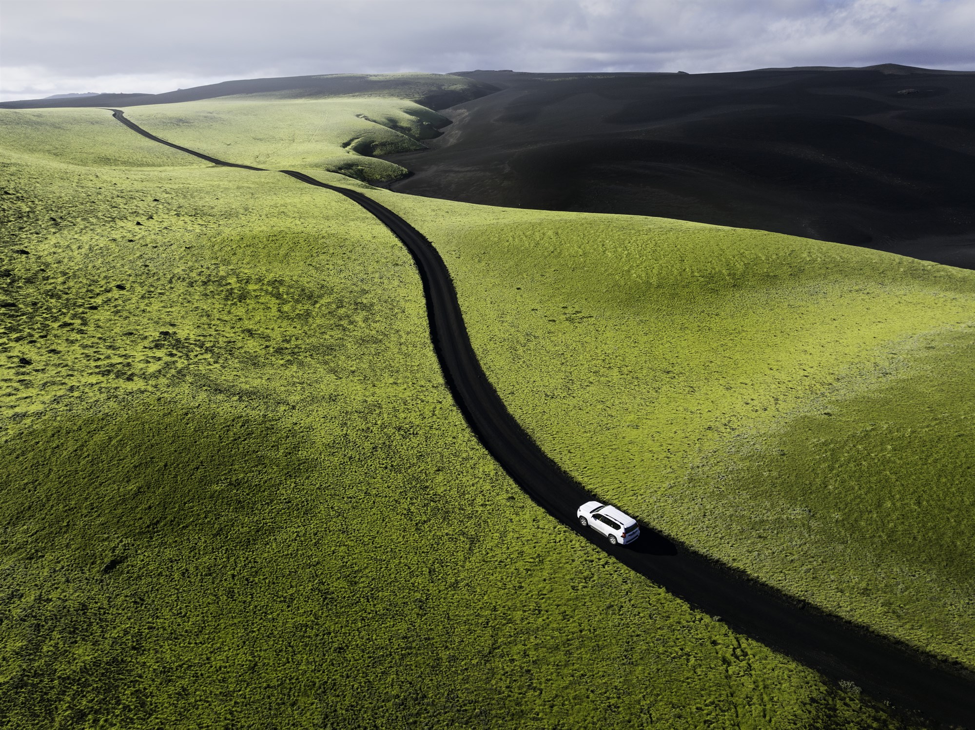 Scenic Icelandic road with a rental car in the landscape