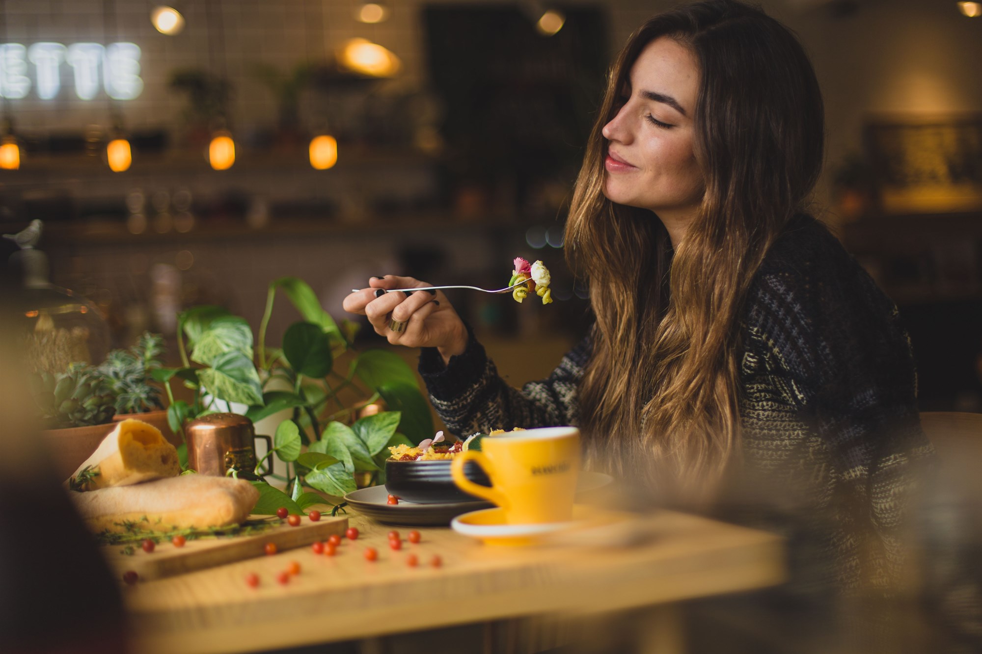 Woman enjoying a salad in a nicely lit restaurant